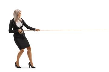 Full length profile shot of a young attractive businesswoman pulling a rope - obrazy, fototapety, plakaty