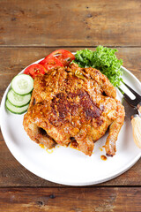 Ayam bakar Taliwang  is a traditional roast chicken from Lombok Indonesia on a wooden background.