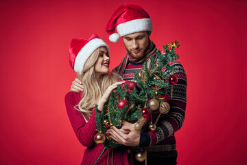 Fototapeta na wymiar man and woman christmas tree toys fun holiday red background