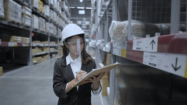 Business concept of 4k Resolution. Asian women intently inspecting items in the warehouse.