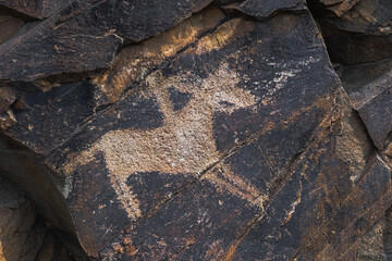 Ancient cave paintings on rocks. Bronze Age, Iron Age and Middle Age rock art. Tanbaly tas petroglyphs in Kazakhstan. UNESCO World Heritage. Tourism, travel in Kazakhstan concept.