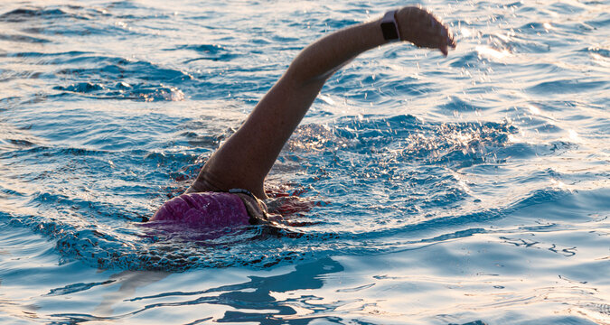 Women swimming in a pool wearing a ponk bathing cap