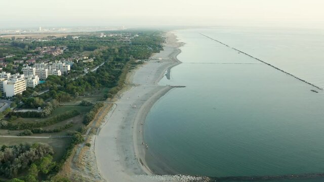 Aerial shot of sandy beach with umbrellas, typical adriatic shore.Summer vacation concept.Lido Adriano town,Adriatic coast, Emilia Romagna,Italy.