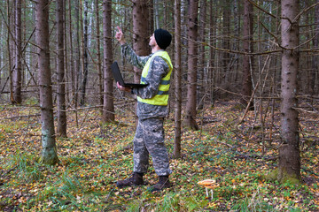 Forest engineer works in the forest with a computer. computer technologies in forest taxation.