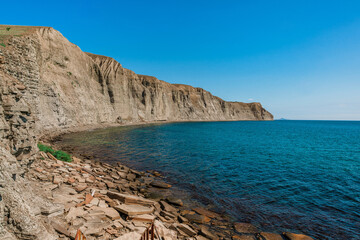 Fototapeta na wymiar A rocky beach made of natural rectangular stones in the Crimea, a gloomy lifeless landscape