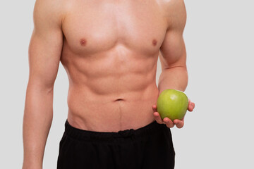 Man Holding Apple Topless. Sportsman with Healthy food in Hands. Muscles, Abs, Biceps, Core....