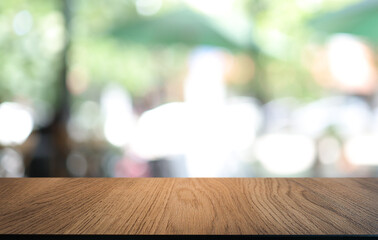 Empty wooden table in front of abstract blurred background of coffee shop . can be used for display...