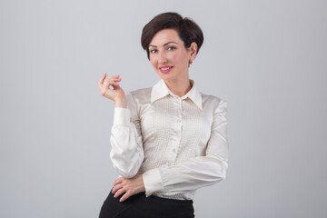 Beautiful business woman with coquettish toothy smile wearing classic formal shirt. Studio portrait of model in 40s posing with playful facial expression. Female with bob haircut and red lipstick