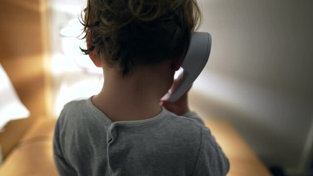 Baby talking on phone in ear. toddler child talks with phone