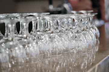 Overturned clean wine glasses on bar counter.