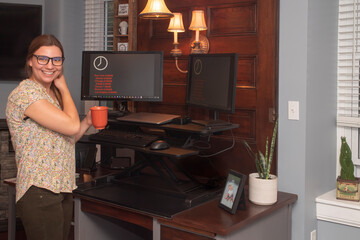 Fototapeta na wymiar Young profeesional woman in her home office with a coffee cup