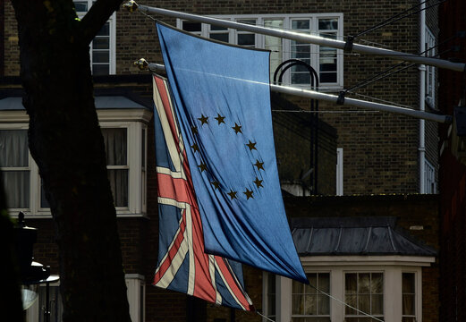 A British Union flag and a European Union flag hang from a building in central London