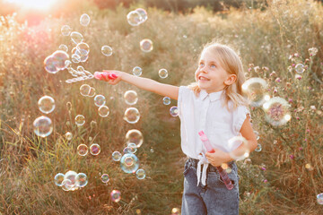 little girl and soap bubbles on a sunset walk