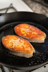 grilling salmon fillet steak on iron skillet pan
