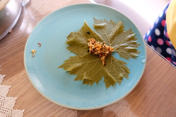 Process of making stuffed grape leaves with olive oil, selective focus. It is called 