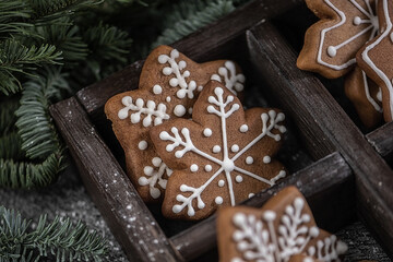 Collection of various gingerbread cookies in a box with fir branches