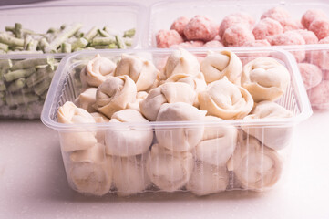 Containers with frozen  vegetables and semi-finished meat products  from the refrigerator. meatballs, dumplings, chopped beans