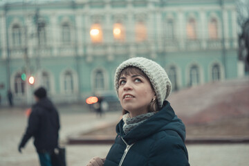 a girl in a winter hat walks around the city