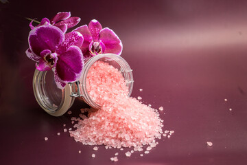 Pink bath salt with orchid flower on vinous background 