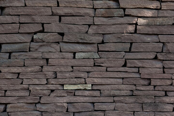 Wall of raw brown stone, masonry texture. Stone background