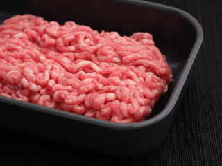 Minced pork and beef in a tray. Low key. Close up.