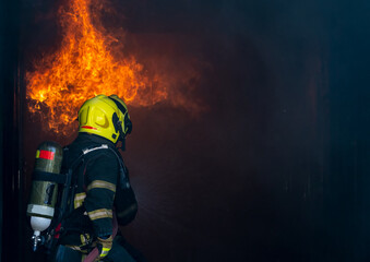 Firefighters with extinguisher spraying high pressure water are fighting fire to prevent fire.