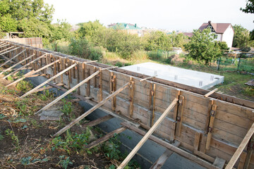 Fototapeta premium Construction site. The timber formwork is prepared for pouring concrete. The metal fittings are also visible. The process of building a private house