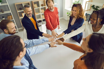 Collaborate community relationship, motivation meeting concept. Happy diverse multi-ethnic people group join helping hands in circle together gesturing common spirit, unity and teamwork in office