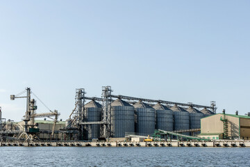 Fototapeta na wymiar grain storage silos on the river bank