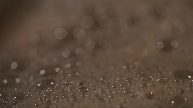 Boiling water in a pot bubbling over. boiling water with air bubbles close up. Bubbles rising up. Boiling water, closeup. Boiled Coffee