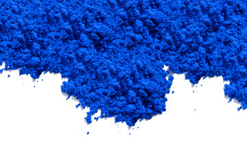 Blue pigment granules and powder strewn on the top of the photo, viewed from above on white. The pigment will be mixed with linseed oil to make oil paint