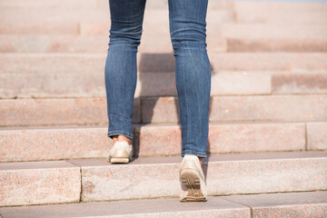 Fototapeta na wymiar Close up of female legs climbing the steps up.