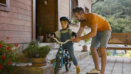 Father teaching his son how to ride a bike.