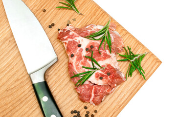 Raw fresh beef meat steaks with rosemary, pepper and knife on cutting board isolated on white...