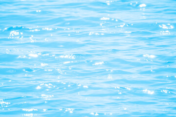 azure water surface with sun glare and ripples on the water