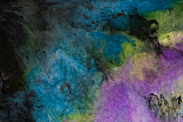 Texture in the style of fluid art. Abstract background with paint mixing effect. Liquid acrylic paint background. Blue, black, white and purple colors.