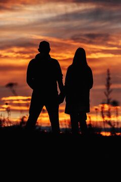 Silhouette of a couple against the background of a beautiful sunset or dawn sky.