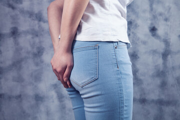 woman in jeans holds the ass. haemorrhoids