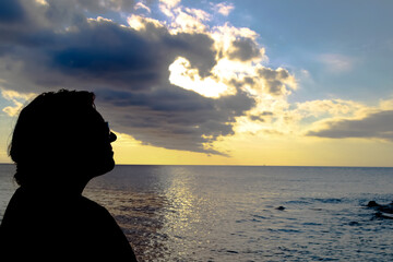 Fototapeta premium Silhouette of woman on the beach during sunset.