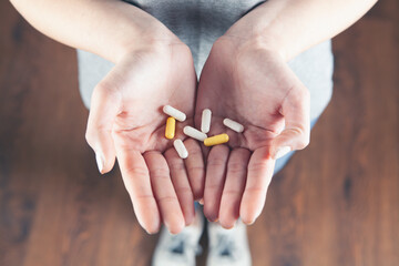 young girl holding pills. view from above