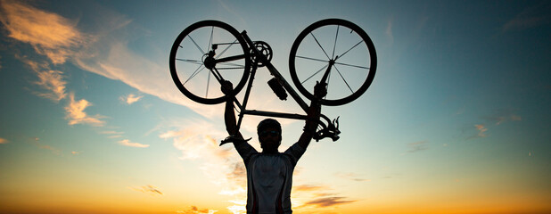 cyclist silhoutte with bicycle raised to sky race and victory concept