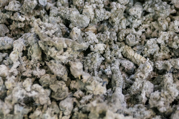 Heap of secondary soft plastic granules - polystyrene, polyethylene, polypropylene pellets at exhibition, trade show - plastic recycling, renewable resource: close up top view