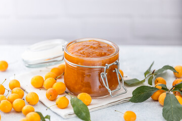 Homemade DIY natural canned yellow cherry plum sauce chutney with chilli or tkemali in glass jar...