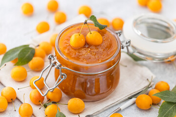 Homemade DIY natural canned yellow cherry plum sauce chutney with chilli or tkemali in glass jar...