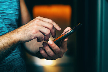 Primer plano de la mano de un hombre sosteniendo su smartphone. Enviando un sms y compartiendo...