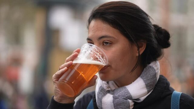 Woman drinking beer pint outside