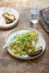 Spaghetti with zucchini and basil pesto on a white plate, rustic style