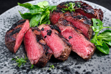 Modern style traditional barbecue dry aged wagyu rib-eye beef steaks with lambs lettuce and black...