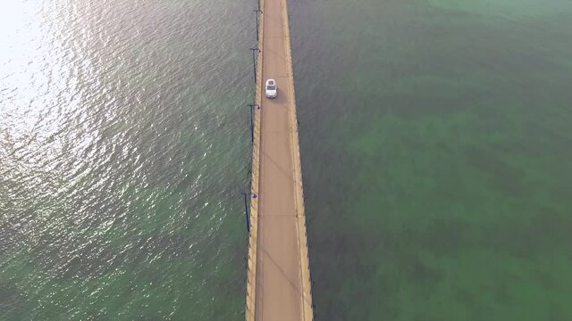 AERIAL: Incredible car on a beautiful bridge INCREASING ALTITUDE IN CENITAL