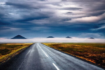 A typical Icelandic landscape and an empty road leads into the distance. Iceland, Europe.